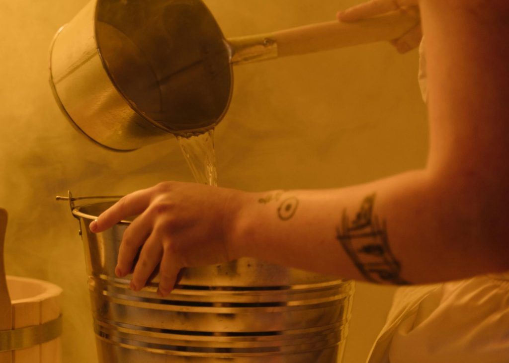 bucket of water during a hammam experience in marrakesh inside a sauna with the steam around
